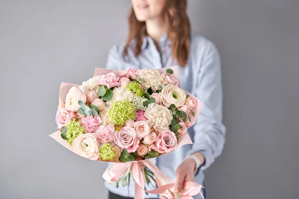 Negozio floreale europeo. Bellissimo bouquet di fiori misti nelle mani delle donne. il lavoro del fioraio in un negozio di fiori. Consegna fresco fiore reciso . — Foto Stock