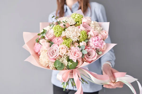 Tienda floral europea. Hermoso ramo de flores mixtas en manos de mujeres. el trabajo de la floristería en una florería. Entrega flor fresca cortada . — Foto de Stock