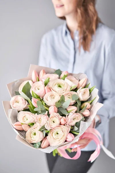 Bunch tulipas rosa pálidas e flores ranúnculos com eucalipto verde. O trabalho da florista em uma loja de flores . — Fotografia de Stock