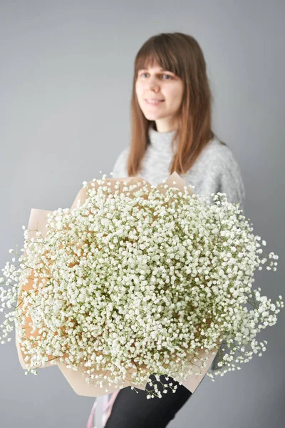 白色的吉普赛葡萄酒女人手里拿着一束美丽的混合花。花店花商的工作。新鲜切花. — 图库照片