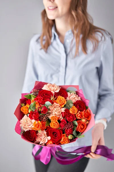 Tienda floral europea. Hermoso ramo de flores mixtas en manos de mujeres. el trabajo de la floristería en una florería. Entrega flor fresca cortada . —  Fotos de Stock