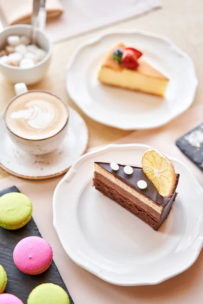 Gâteau aux éponges au chocolat, à la mousse, décoré de tranches d'orange et de meringue. Petit déjeuner au café, café du matin. sur table en bois . — Photo