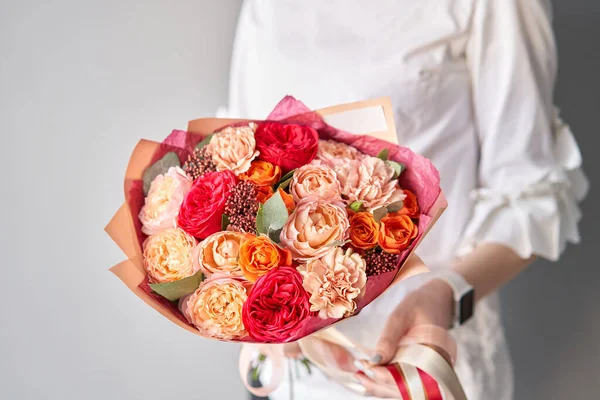 Beautiful bouquet of mixed flowers in womans hands. the work of the florist at a flower shop. Delivery fresh cut flower. European floral shop. — Stock Photo, Image