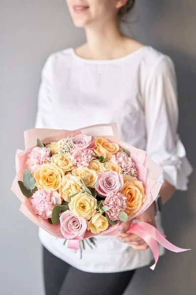 Belo buquê de flores mistas em mãos de mulheres. o trabalho da florista em uma loja de flores. Entrega flor de corte fresco. Loja floral europeia. — Fotografia de Stock