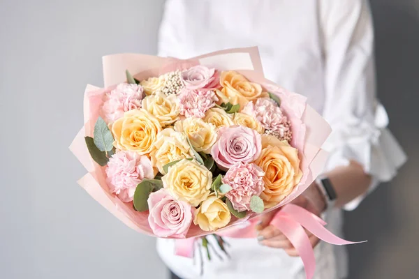 Beau bouquet de fleurs mélangées dans les mains des femmes. le travail du fleuriste dans un magasin de fleurs. Livraison fleur fraîche coupée. Fleuriste européen. — Photo