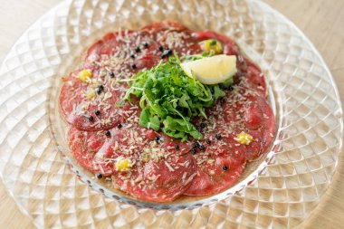 Balzamik havyarlı biftek carpaccio ve ahşap masa arkasında parmesan peyniri. Restoran menüsü, doğal ve organik gıda konsepti..
