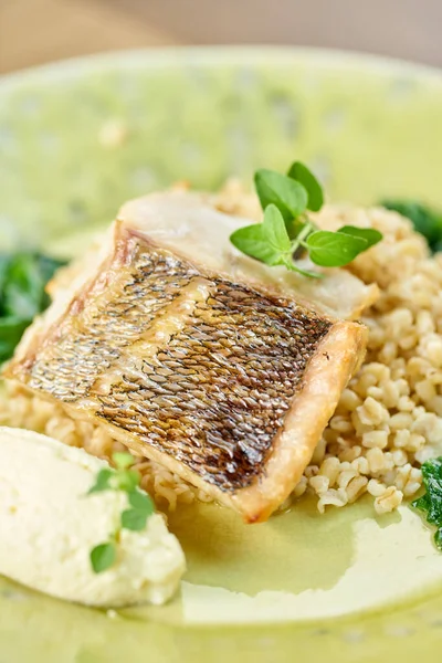 Roasted Pike perch with spelt and Polish sauce. Dish decorated with a spinach. Restaurant menu — Stock Photo, Image