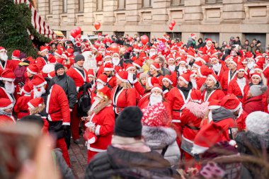 Riga, Letonya - 08 Aralık 2019. Aralık ayındaki yıllık Noel Baba Koşu Yürüyüşü 'nün kimliği belirsiz katılımcıları. Riga Noel Baba Yarışı Eski Şehir 'de, Kubbe Meydanı' ndaki Noel pazarında başladı..