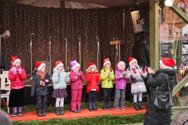 Riga, Letonya - 08 Aralık 2019. Çocuklar şarkı söyler. Çocuklar eski kasabadaki Dome Meydanı 'ndaki Noel pazarında konser veriyorlar..
