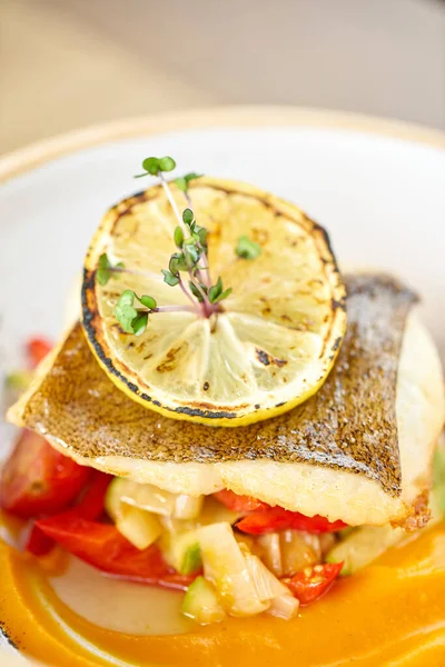 Süllő, sügérhal, sült zöldségekkel. Edényt díszített egy szelet citrommal. Étteremmenü — Stock Fotó