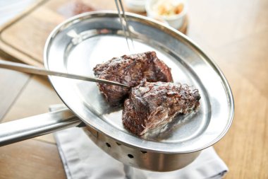 Çeşitli ızgara et ve iki soslu lahana turşusu. Tahta bir tahtanın üzerinde hizmet veriyor. Barbekü lokantası menüsü, bir dizi farklı etin fotoğrafları..