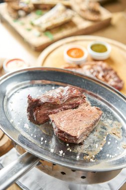 Izgara fileto biftek. İkiye bölünmüş bir parça et. Barbekü restoranı menüsü. Metal bir tabakta, kömürle. Chateaubriand bifteği