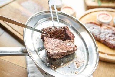 Çeşitli ızgara et ve iki soslu lahana turşusu. Tahta bir tahtanın üzerinde hizmet veriyor. Barbekü lokantası menüsü, bir dizi farklı etin fotoğrafları..