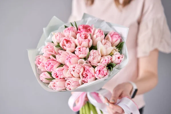 Pink pastel color tulips in woman hand. Young beautiful woman holding a spring bouquet. Bunch of fresh cut spring flowers in female hands — 스톡 사진