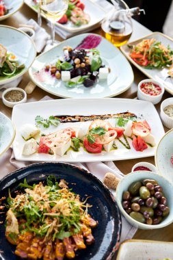 Masada bir sürü farklı lezzetli yemek var. Masada çeşitli abur cuburlar ve antipastalar var. Restoran menüsü. İtalyan mutfağı