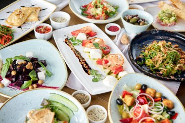 Masada bir sürü farklı lezzetli yemek var. Masada çeşitli abur cuburlar ve antipastalar var. Restoran menüsü. İtalyan mutfağı