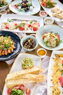 Masada bir sürü farklı lezzetli yemek var. Masada çeşitli abur cuburlar ve antipastalar var. Restoran menüsü. İtalyan mutfağı