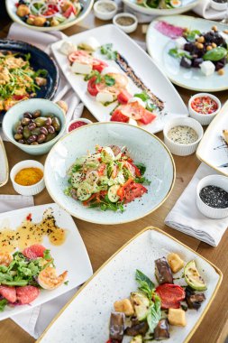 Masada bir sürü farklı lezzetli yemek var. Masada çeşitli abur cuburlar ve antipastalar var. Restoran menüsü. İtalyan mutfağı