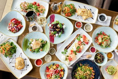 Masada bir sürü farklı lezzetli yemek var. Masada çeşitli abur cuburlar ve antipastalar var. Restoran menüsü. İtalyan mutfağı