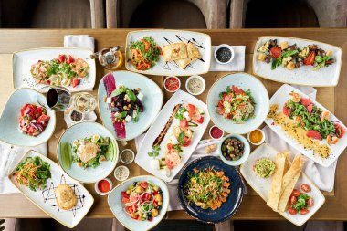 Masada bir sürü farklı lezzetli yemek var. Masada çeşitli abur cuburlar ve antipastalar var. Restoran menüsü. İtalyan mutfağı