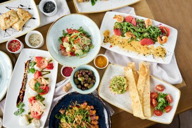 Masada bir sürü farklı lezzetli yemek var. Masada çeşitli abur cuburlar ve antipastalar var. Restoran menüsü. İtalyan mutfağı