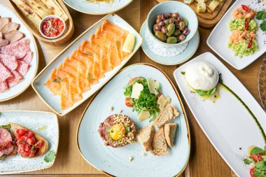 Restoranda et tartarı var. Tabakların çeşitleri masada. Masada çeşitli abur cuburlar ve antipastalar var. Restoran menüsü. İtalyan mutfağı