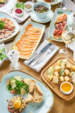 Restoranda et tartarı var. Tabakların çeşitleri masada. Masada çeşitli abur cuburlar ve antipastalar var. Restoran menüsü. İtalyan mutfağı