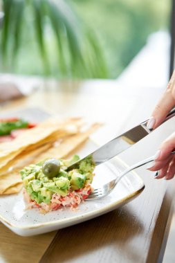 Kadınlar salata yengeci, avokado, narenciye yağı ve baharat yer. Pişmiş deniz ürünleri için beyaz tabakta matza ile yengeç eti..