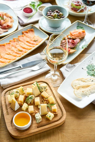 Un plato de queso. Enfócate en la deliciosa mezcla de queso con nueces, miel en mesa de madera. Varios aperitivos y antipasti en la mesa. Menú restaurante . — Foto de Stock