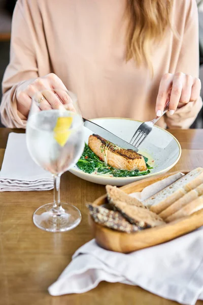 Salmon steak fillet with grainy mustard and spinach. Lunch in a restaurant, a woman eats delicious and healthy food. Restaurant menu, a series of photos of different dishes — Stock Photo, Image