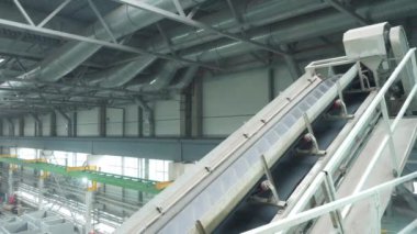 Karıştırıcıdaki malzemelerin taşıyıcı bandı. House-Building fabrikasının atölyesinde çalışanlar. Endüstriyel iç mekan. Beton fabrikası.