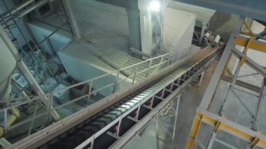 Karıştırıcıdaki malzemelerin taşıyıcı bandı. House-Building fabrikasının atölyesinde çalışanlar. Endüstriyel iç mekan. Beton fabrikası.