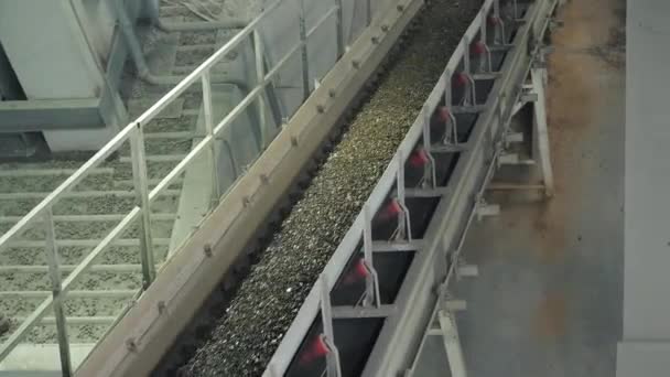 The conveyor belt of ingredients to the mixer. Workers in the workshop of the House-building plant. Industrial interior. Concrete plant. — Stock Video