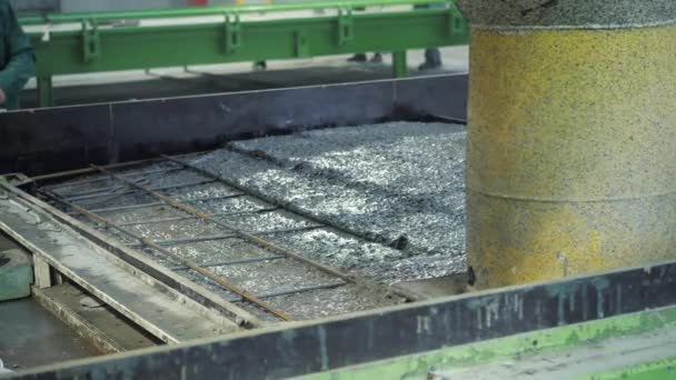 Büyük bir uzaktan kumandalı makine betonu form olarak doldurur. House-Building fabrikasının atölyesinde çalışanlar. Endüstriyel iç mekan. Beton fabrikası. — Stok video