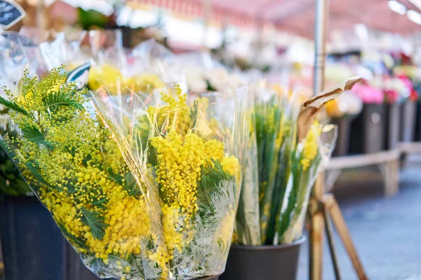 Primavera Mimosa. Manojos de diferentes flores de colores en cubos en el mercado de flores de la calle en Anemone, amapola — Foto de Stock
