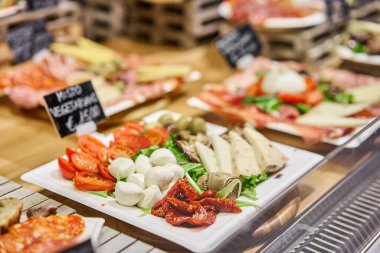 Vejetaryen menüsü. Hafif İtalyan atıştırmalıkları. Domatesli ve zeytinli peynir tabağı. Ahşap tabakta lezzetli peynir karışımı. İtalya, Floransa 'da sokak gıda pazarı.