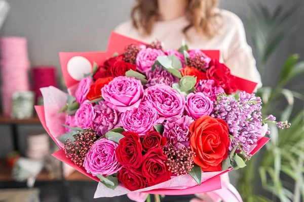 Heldere bes kleur, Mooi boeket van gemengde bloemen in vrouwen handen. het werk van de bloemist in een bloemenwinkel. Levering verse snijbloem. Europese bloemenwinkel. — Stockfoto