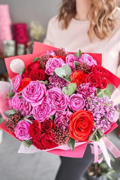 Cor de baga brilhante, belo buquê de flores mistas em mãos de mulheres. o trabalho da florista em uma loja de flores. Entrega flor de corte fresco. Loja floral europeia . — Fotografia de Stock