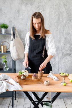 Kadın bahçıvanın ampul nakli yapan elleri ahşap masadaki çimento kaplarındaki sümbüller. Ev bahçesi kavramı. Çiçek ve bahçe dükkanı.