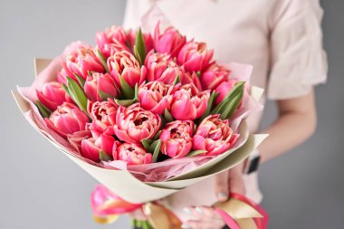 Bir demet taze bahar çiçeği. Kadın elinde kırmızı laleler. Bahar buketi kırmızı laleler ellerinde.