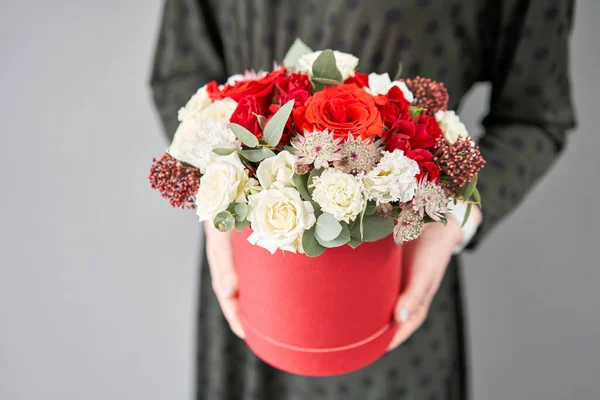 Kırmızı ve beyaz çiçek tohumu yuvarlak kutuda. Avrupa çiçekçisi. Bir buket güzel Karışık çiçekler kadının elinde. — Stok fotoğraf