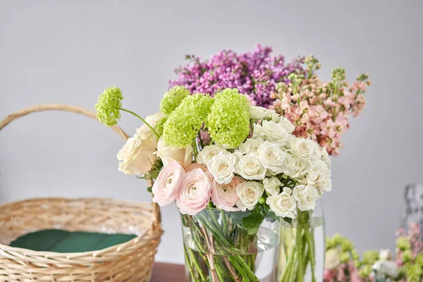 Educación en la escuela de floristería. Clase magistral en hacer ramos. Ramo de verano en una canasta de mimbre.. Aprendiendo arreglos florales, haciendo hermosos ramos con sus propias manos. Entrega de flores — Foto de Stock