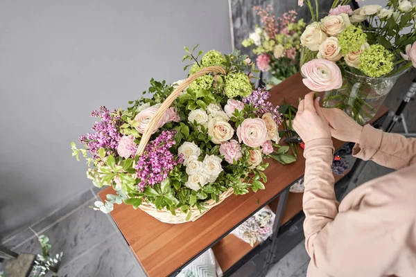 Educación en la escuela de floristería. Clase magistral en hacer ramos. Ramo de verano en una canasta de mimbre.. Aprendiendo arreglos florales, haciendo hermosos ramos con sus propias manos. Entrega de flores —  Fotos de Stock