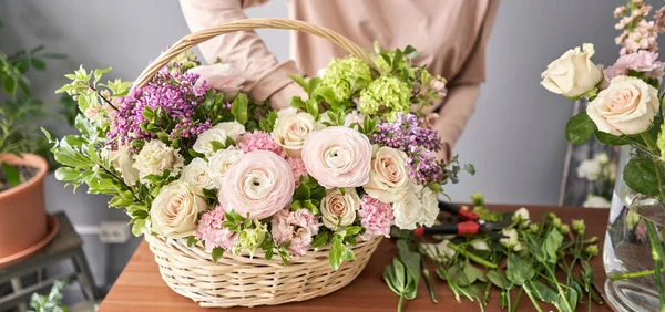 Spring bouquet in a wicker basket.. Learning flower arranging, making beautiful bouquets with your own hands. Flowers delivery