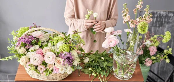 Educación en la escuela de floristería. Clase magistral en hacer ramos. Ramo de verano en una canasta de mimbre.. Aprendiendo arreglos florales, haciendo hermosos ramos con sus propias manos. Entrega de flores — Foto de Stock