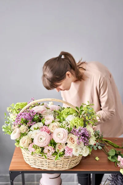 Concept de boutique florale. Fleuriste femme crée arrangement de fleurs dans un panier en osier. Beau bouquet de fleurs mélangées. Un beau bouquet frais. Livraison de Fleurs . — Photo