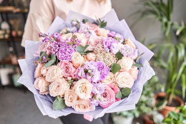 Avrupa çiçekçisi. Kadınların elinde güzel bir buket karışık çiçek. Çiçekçi dükkanındaki çiçekçinin işi. Taze kesilmiş çiçek getirdim..