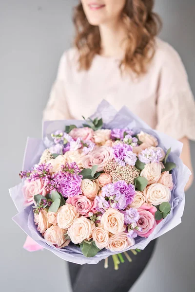 Negozio floreale europeo. Bellissimo bouquet di fiori misti nelle mani delle donne. il lavoro del fioraio in un negozio di fiori. Consegna fresco fiore reciso . — Foto Stock