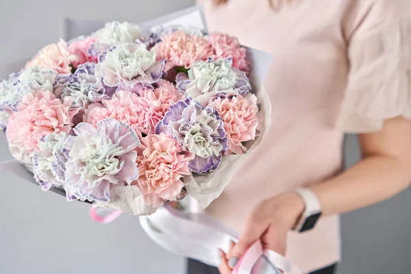 Bouquet von Nelkenblüten Pastellfarbe. Frühlingsstrauß in Frauenhand. Geschenk zum Muttertag. — Stockfoto