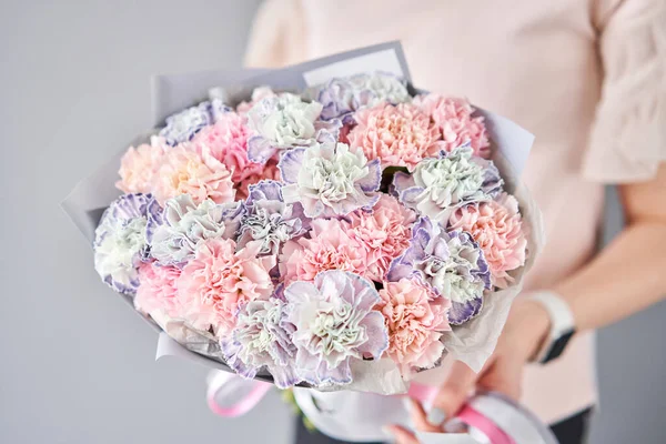 Bouquet von Nelkenblüten Pastellfarbe. Frühlingsstrauß in Frauenhand. Geschenk zum Muttertag. — Stockfoto